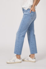 Model trägt einen Kurzarmpulli der Marke Joop! in Weiß, eine Jeans der Marke 7 for all mankind in hellblau.