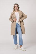 Model trägt einen Kurzarmpulli der Marke Joop! in Weiß, eine Jeans der Marke 7 for all mankind in hellblau, einen Mantel der Marke Save the Duck in Camel.