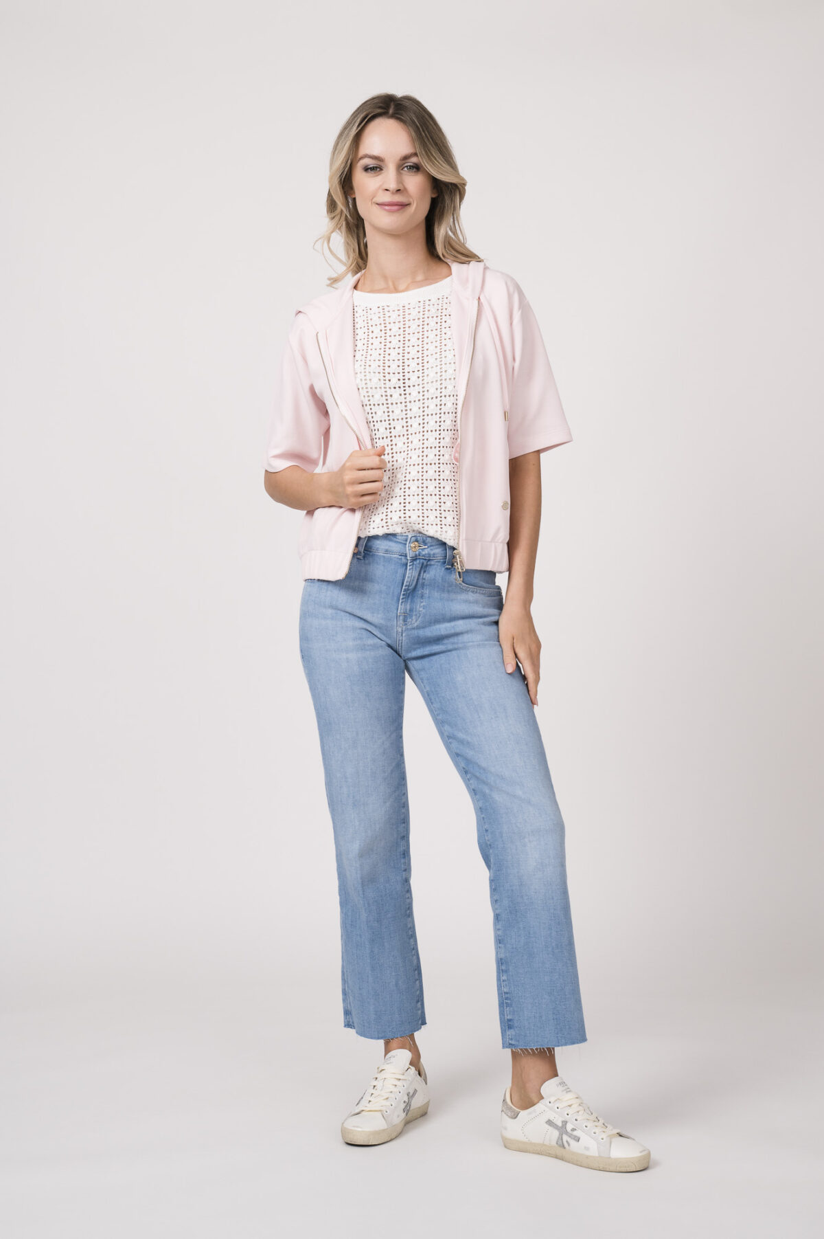 Model trägt einen Kurzarmpulli der Marke Joop! in Weiß, eine Jeans der Marke 7 for all mankind in hellblau, einen Lounge Sweater der Marke Joop! in Rosa.