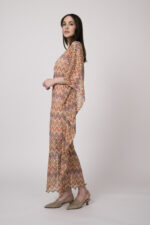 Model trägt ein oranges gemustertes, asymmetrisches Strickkleid von Ana Alcazar.