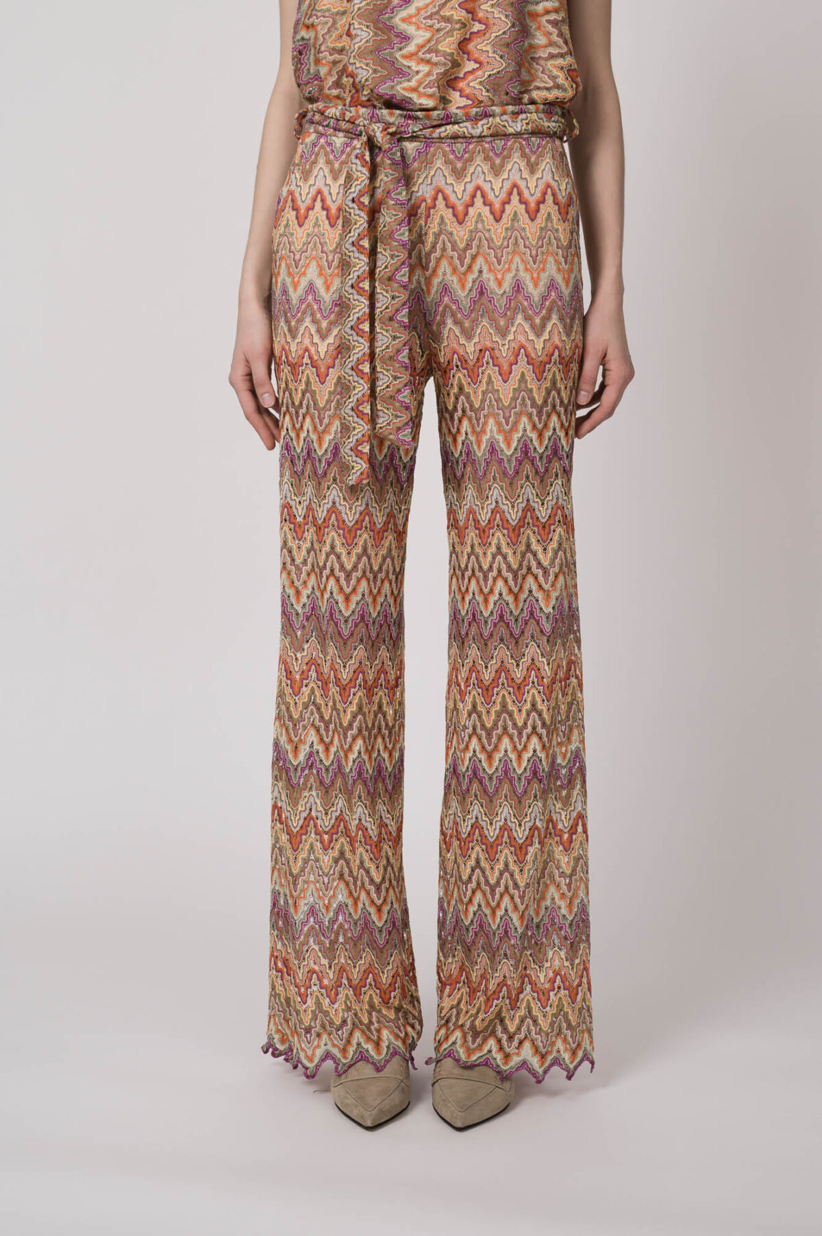 Model trägt eine orange gemusterte Strickhose von Ana Alcazar.