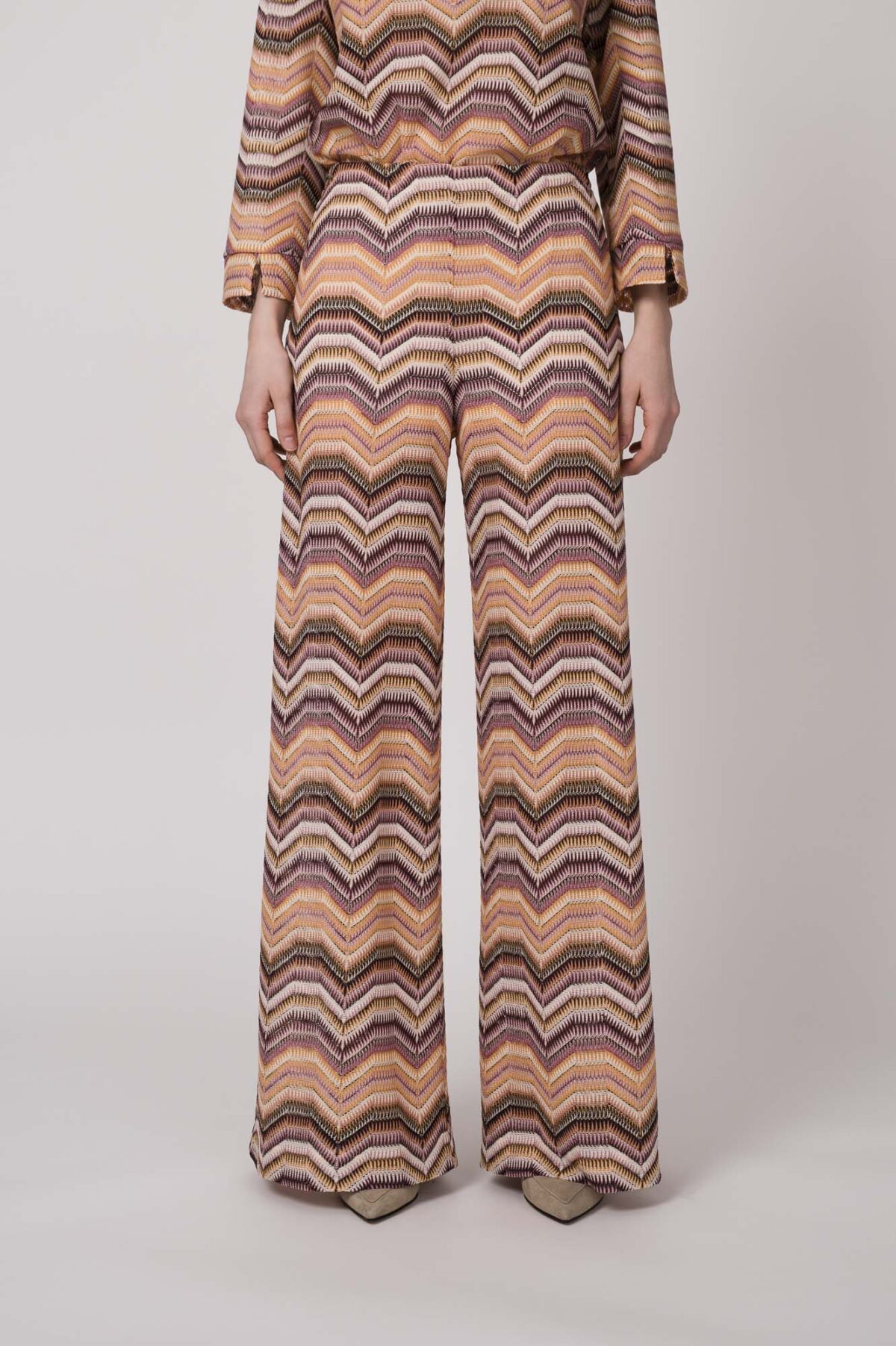 Model trägt eine orange gemusterte Strickhose von Ana Alcazar.