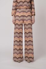 Model trägt eine orange gemusterte Strickhose von Ana Alcazar.