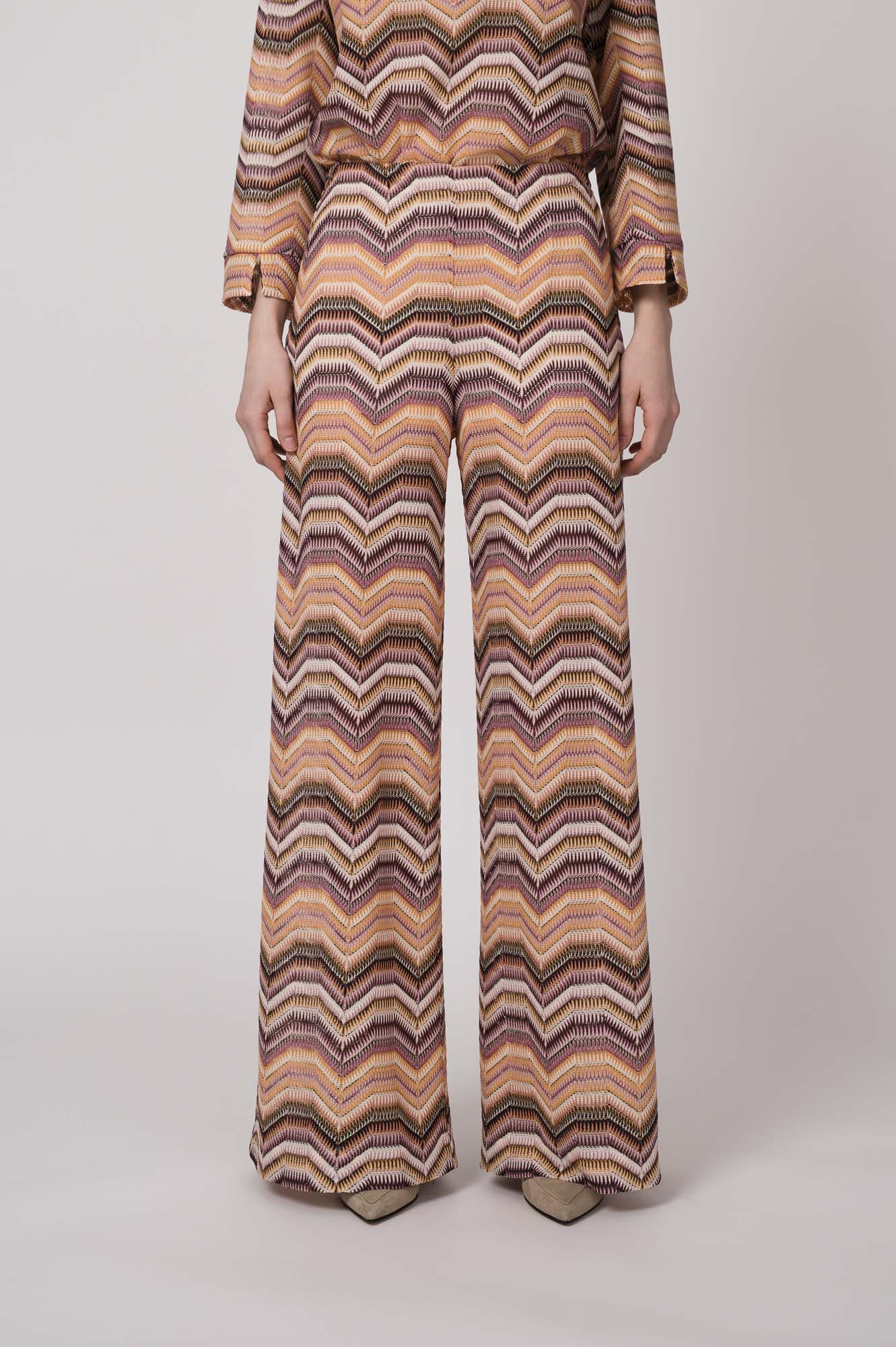 Model trägt eine orange gemusterte Strickhose von Ana Alcazar.