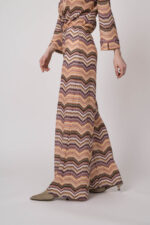 Model trägt eine orange gemusterte Strickhose von Ana Alcazar.