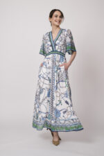 Model trägt ein weiß, blau und grün gemustertes Kleid der Marke Hale Bob.