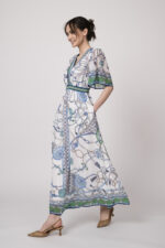 Model trägt ein weiß, blau und grün gemustertes Kleid der Marke Hale Bob.