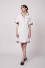 Model trägt ein weißes Kleid am Polo-Shirt-Stil mit blau-weißen Details der Marke Joop!