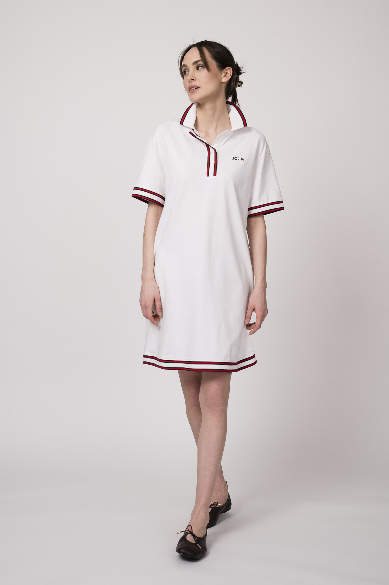 Model trägt ein weißes Kleid am Polo-Shirt-Stil mit blau-weißen Details der Marke Joop!