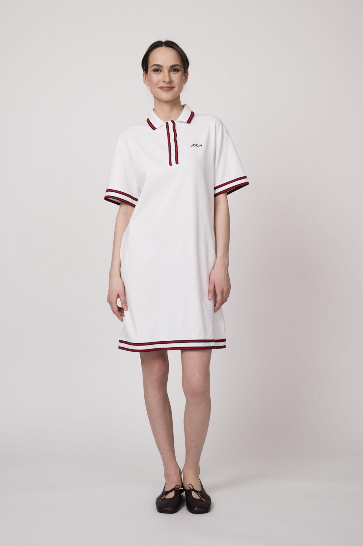 Model trägt ein weißes Kleid am Polo-Shirt-Stil mit blau-weißen Details der Marke Joop!