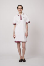 Model trägt ein weißes Kleid am Polo-Shirt-Stil mit blau-weißen Details der Marke Joop!