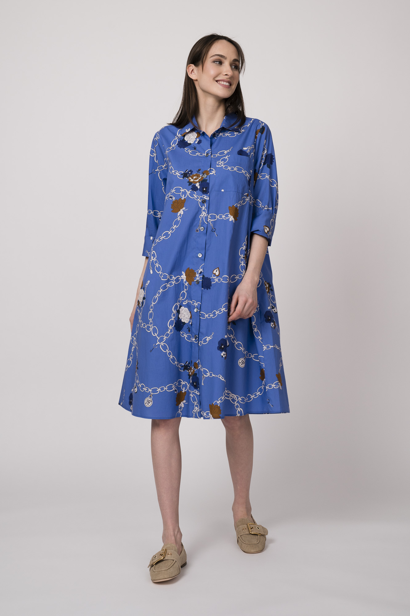 Model trägt ein blaues Hemdblusenkleid mit Kettenmuster der Marke Robert Friedman.