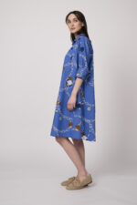 Model trägt ein blaues Hemdblusenkleid mit Kettenmuster der Marke Robert Friedman.