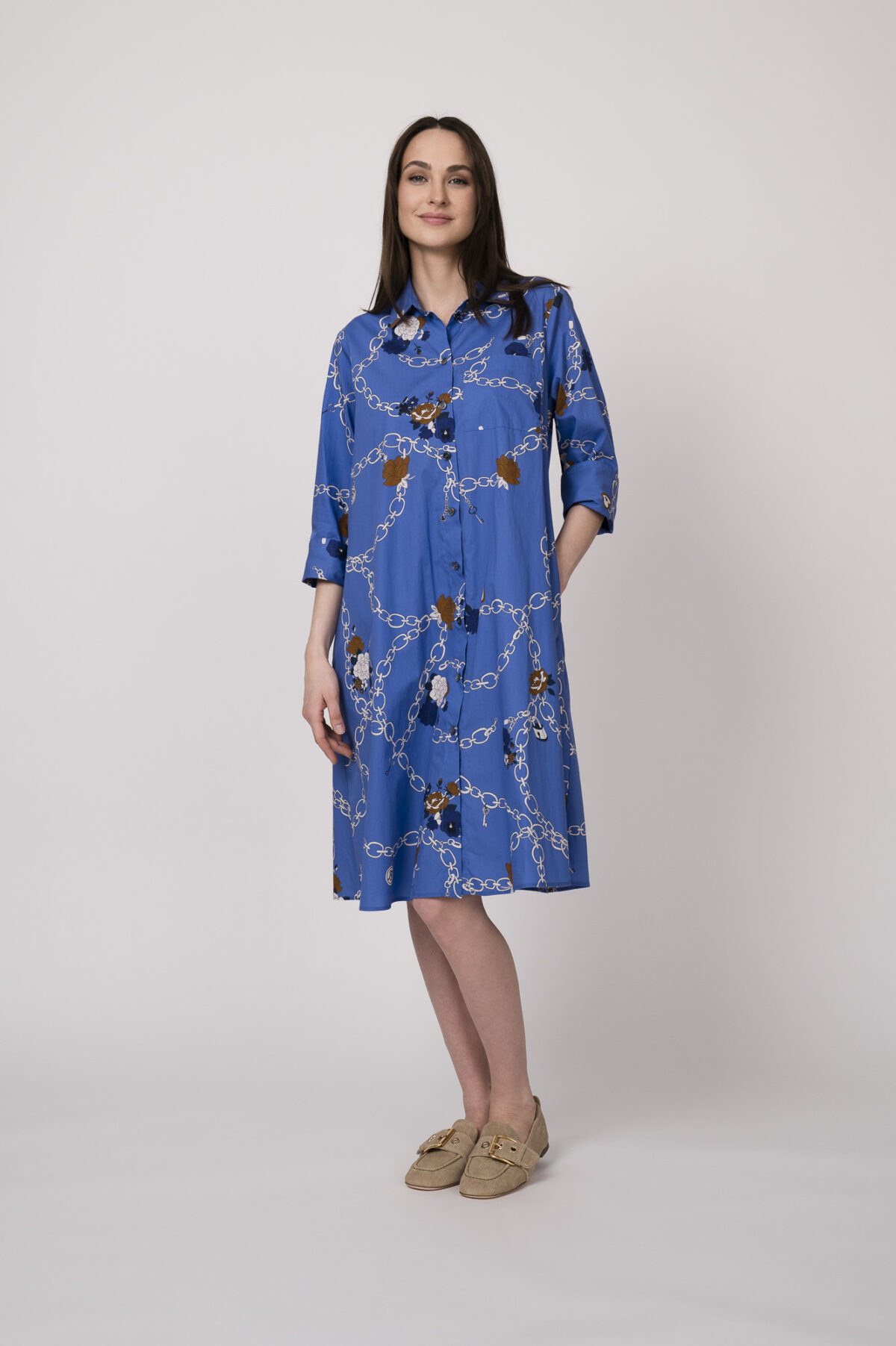 Model trägt ein blaues Hemdblusenkleid mit Kettenmuster der Marke Robert Friedman.