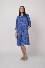 Model trägt ein blaues Hemdblusenkleid mit Kettenmuster der Marke Robert Friedman.