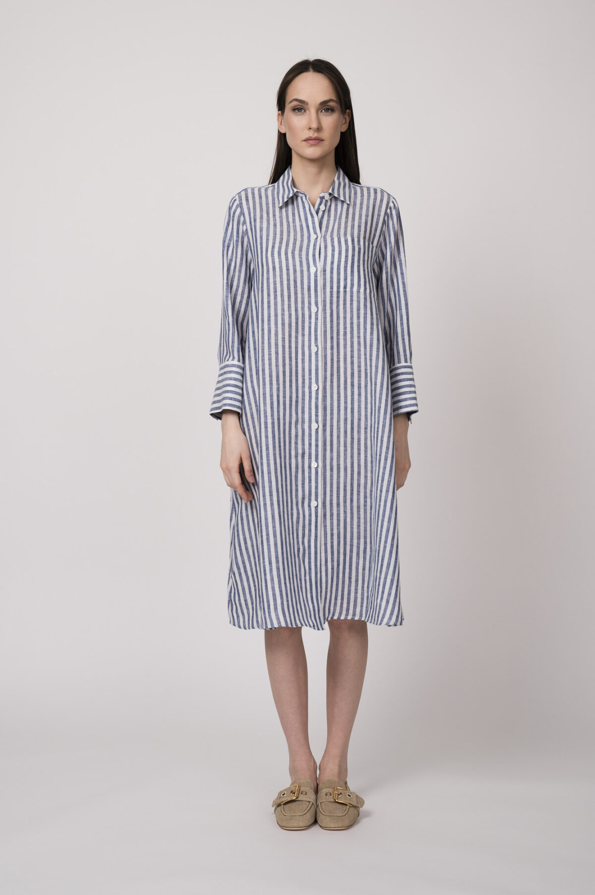 Model trägt ein blau-weiß gestreiftes Hemdblusenkleid der Marke Robert Friedman.