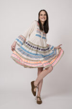 Model trägt ein bunt gestreiftes kurzes Kleid der Marke Devotion.