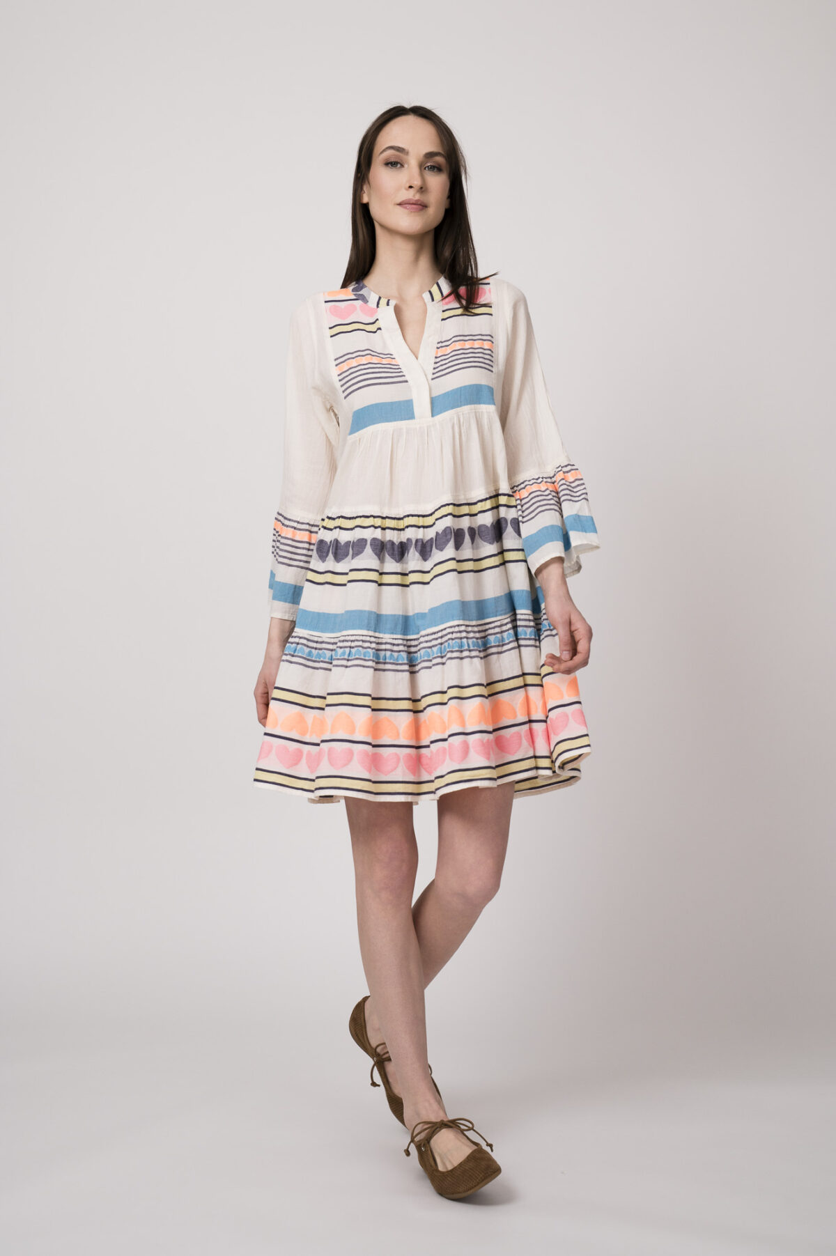 Model trägt ein bunt gestreiftes kurzes Kleid der Marke Devotion.