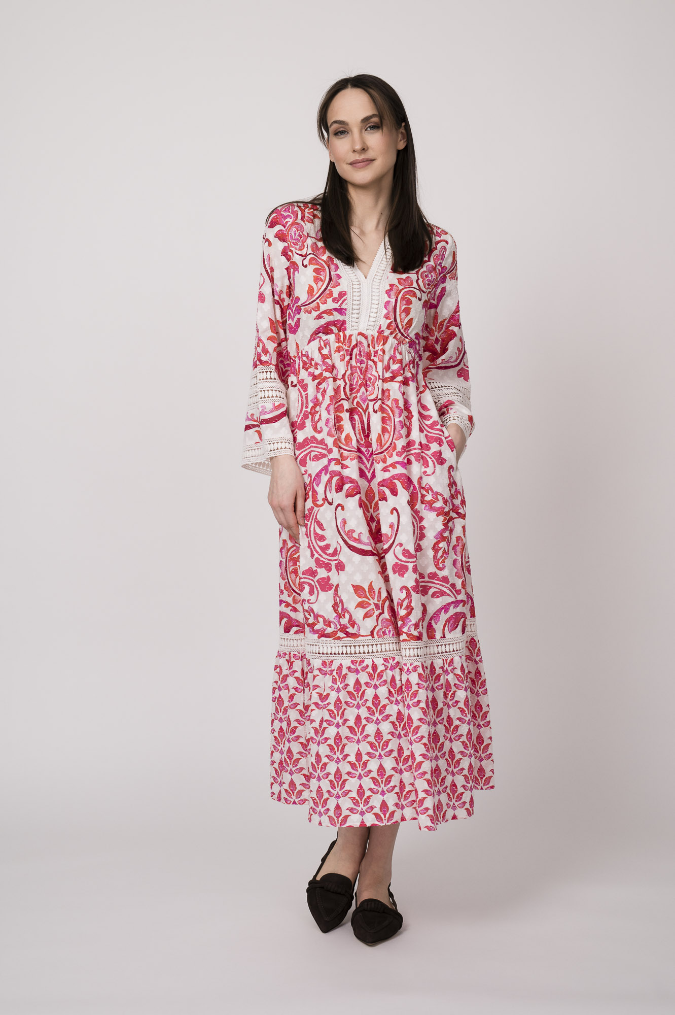 Model trägt ein weiß und rot gemustertes Kleid der Marke Grace.