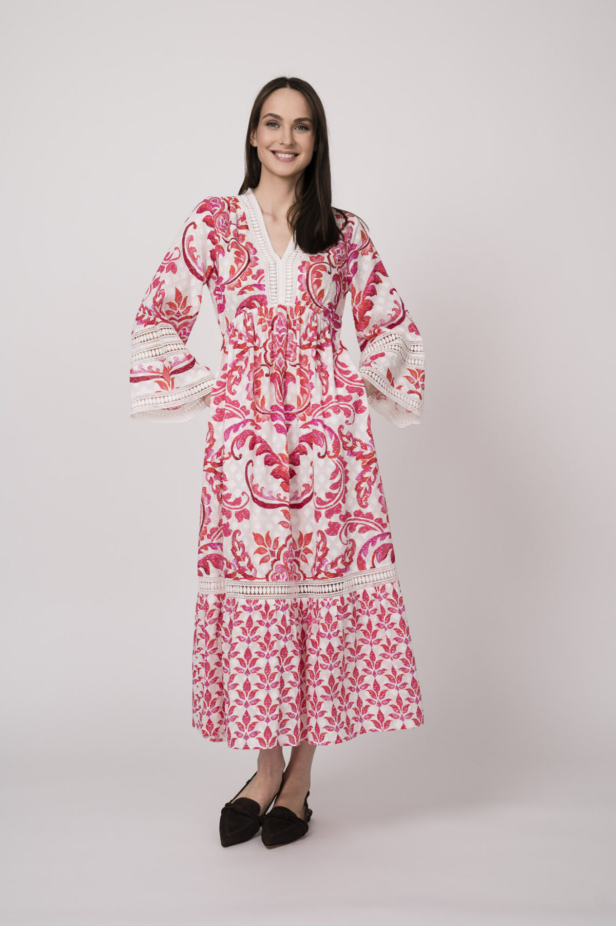 Model trägt ein weiß und rot gemustertes Kleid der Marke Grace.