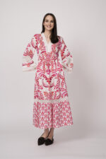 Model trägt ein weiß und rot gemustertes Kleid der Marke Grace.