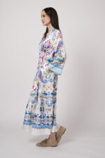 Model trägt ein weißes Kleid mit bunten Mustern der Marke Grace.