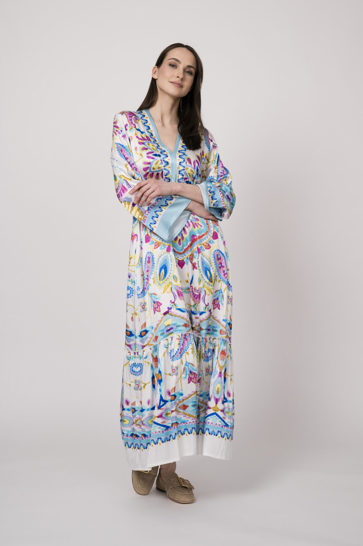 Model trägt ein weißes Kleid mit bunten Mustern der Marke Grace.