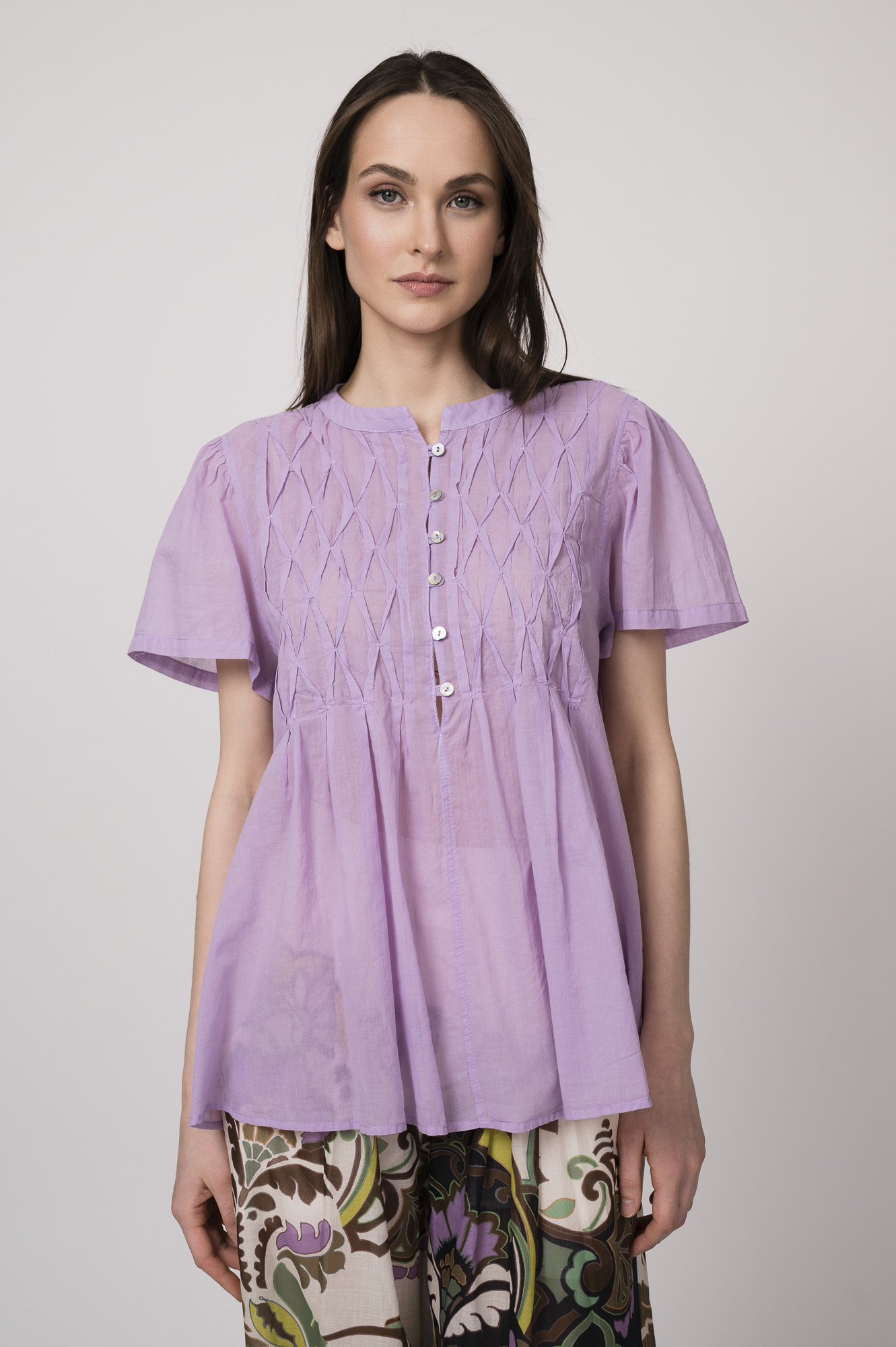 Model trägt eine flieder-farbige Bluse der Marke Devotion.