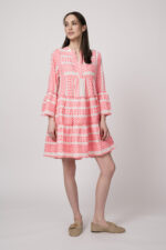 Model trägt ein neon-pink und beige gemustertes, kurzes Kleid der Marke Devotion.