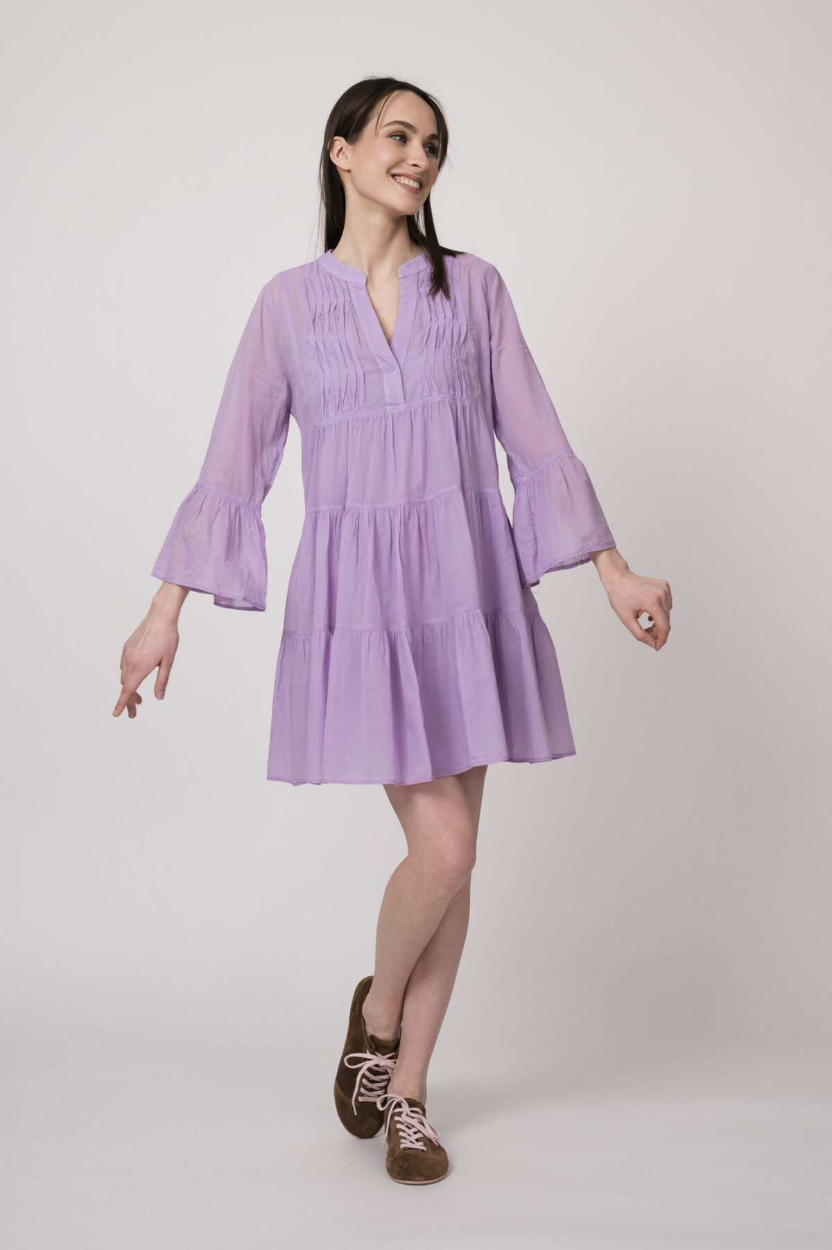 Model trägt ein flieder-farbiges, kurzes Kleid der Marke Devotion.