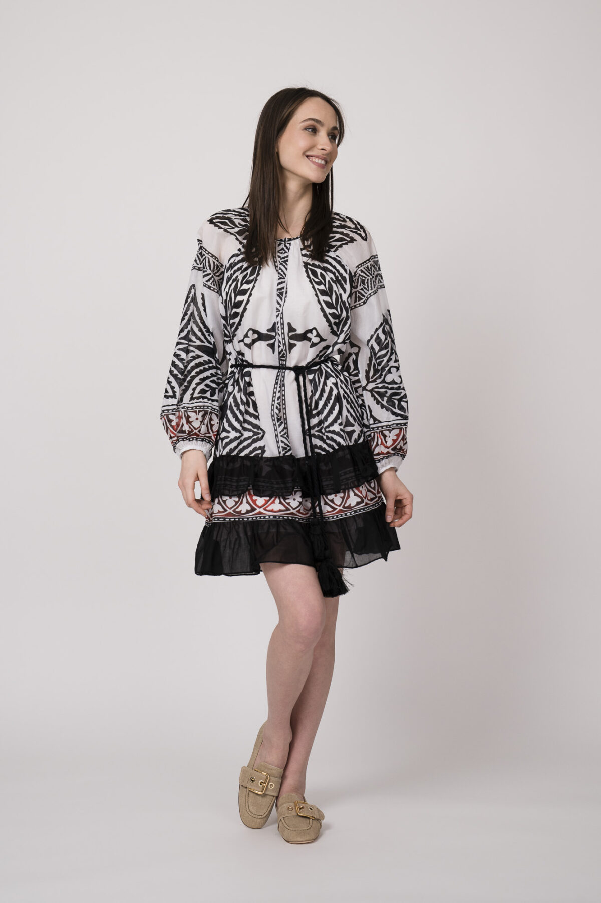 Model trägt ein schwarz-weiß gemustertes, kurzes Kleid der Marke Devotion.