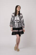 Model trägt ein schwarz-weiß gemustertes, kurzes Kleid der Marke Devotion.