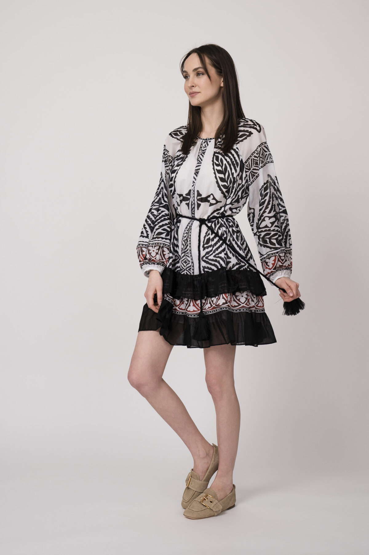 Model trägt ein schwarz-weiß gemustertes, kurzes Kleid der Marke Devotion.