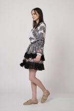 Model trägt ein schwarz-weiß gemustertes, kurzes Kleid der Marke Devotion.