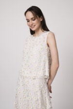 Model trägt ein weißes Top mit Tüll und Gänseblümchen-Applikationen der Marke Luisa Cerano.