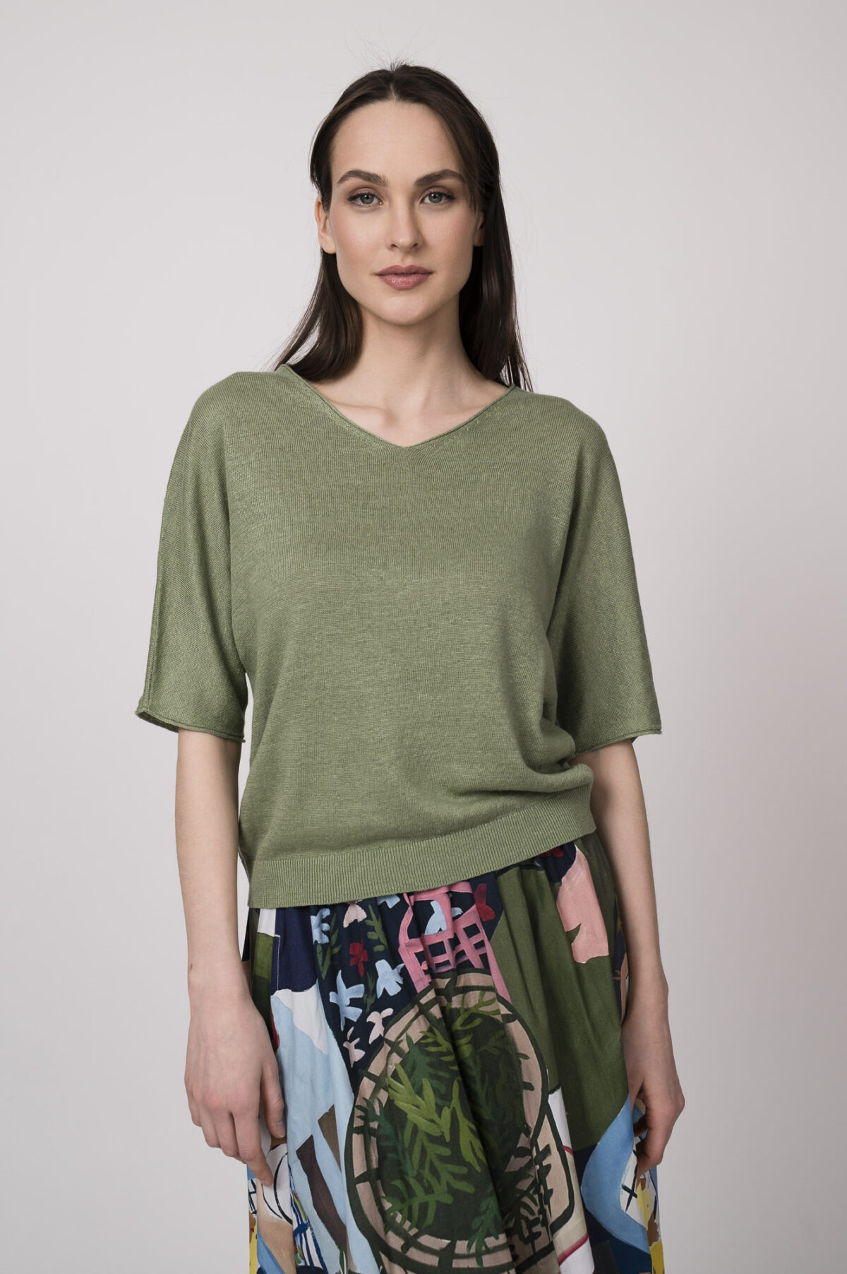 Model trägt einen grünen Kurzarmpullover der Marke Luisa Cerano.