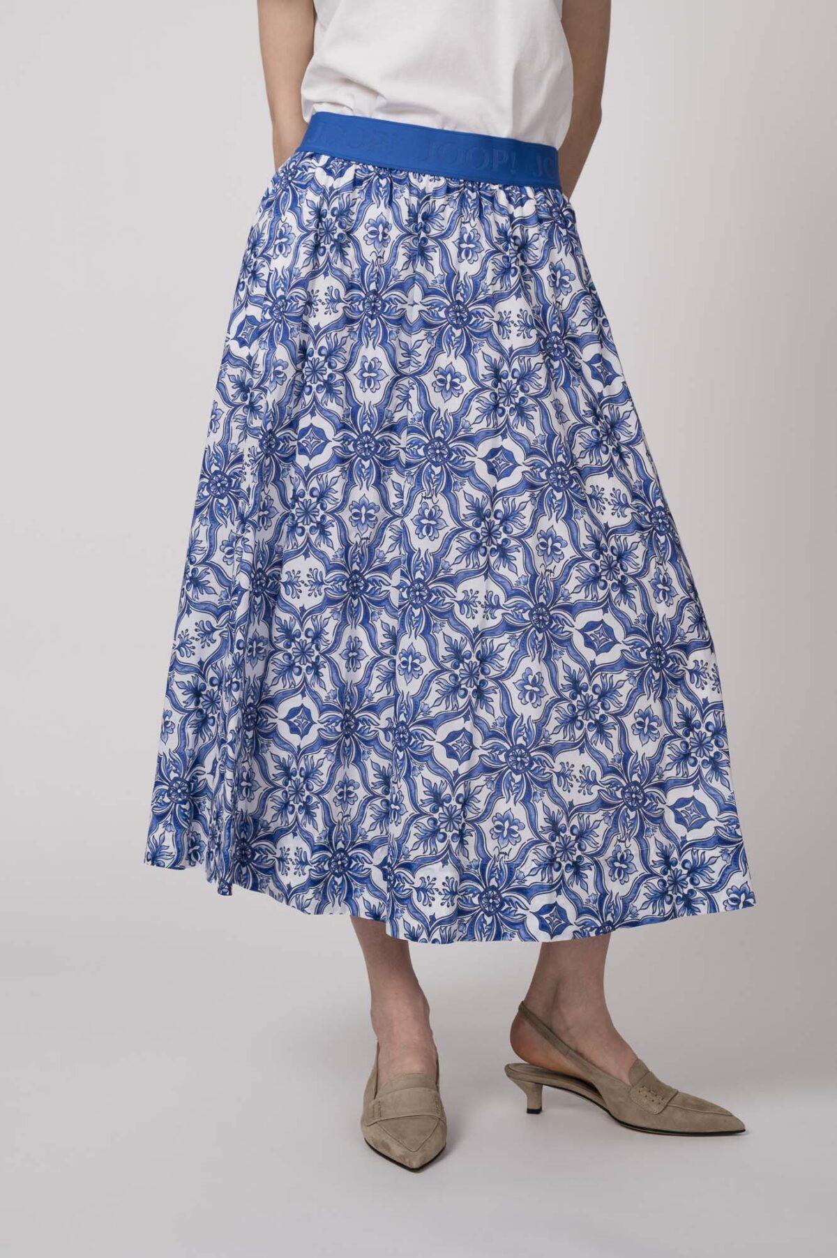 Model trägt einen blau-weiß gemusterten Rock der Marke Joop!