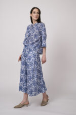 Model trägt eine blau-weiß gemusterte Bluse und einen blau-weiß gemusterten Rock der Marke Joop!