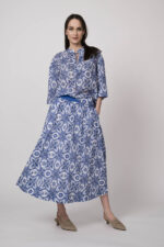 Model trägt eine blau-weiß gemusterte Bluse und einen blau-weiß gemusterten Rock der Marke Joop!