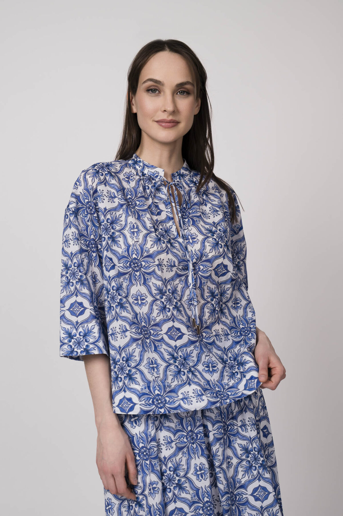 Model trägt eine blau-weiß gemusterte Bluse der Marke Joop!