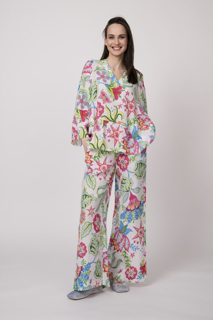 Model trägt eine bunt gemusterte Bluse und Hose der Marke Grace.