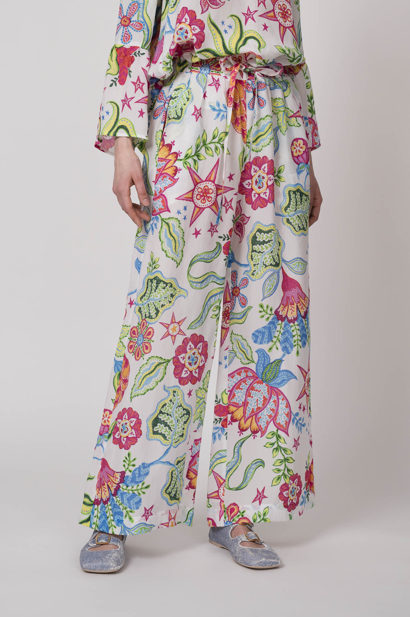 Model trägt eine bunt gemusterte Hose der Marke Grace.