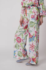 Model trägt eine bunt gemusterte Hose der Marke Grace.