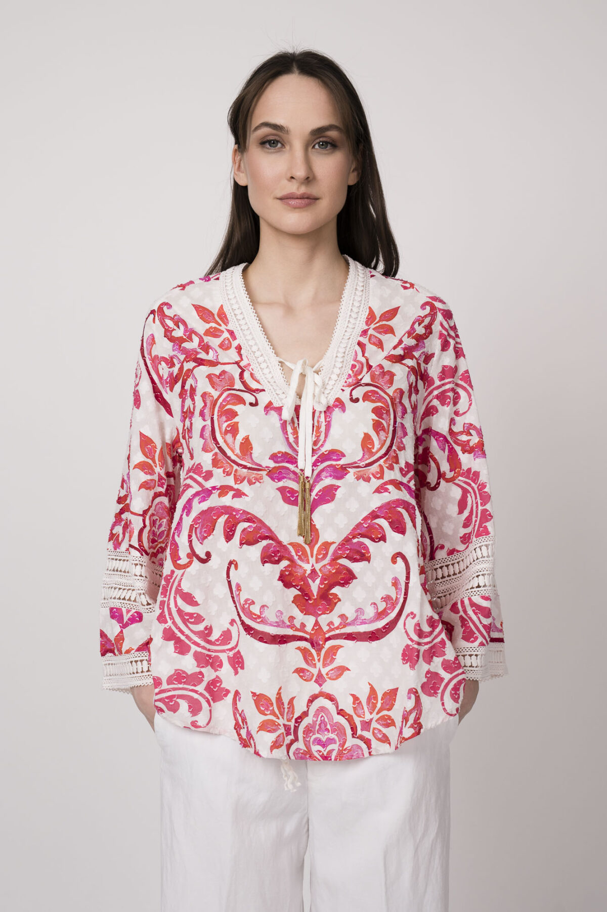 Model trägt eine Tunika mit weiß-rotem Printmuster der Marke Grace