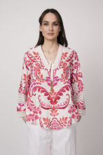 Model trägt eine Tunika mit weiß-rotem Printmuster der Marke Grace