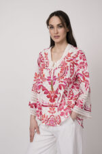 Model trägt eine Tunika mit weiß-rotem Printmuster der Marke Grace