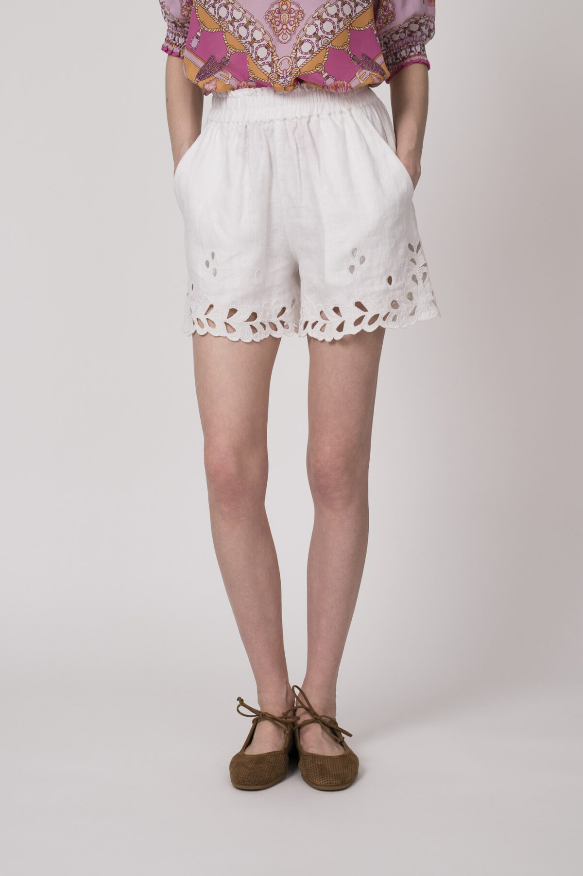 Model trägt eine weiße Shorts mit Cutouts der Marke 0039Italy.