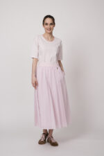 Model trägt ein weiß rosa gestreiftes Shirt und einen rosa Rock der Marke Joop!