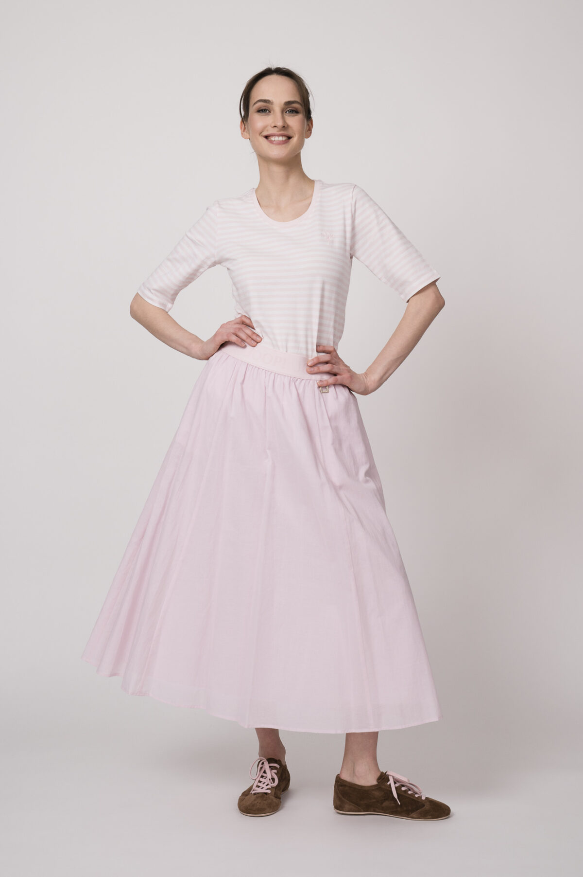 Model trägt ein weiß rosa gestreiftes Shirt und einen rosa Rock der Marke Joop!