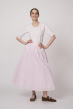 Model trägt ein weiß rosa gestreiftes Shirt und einen rosa Rock der Marke Joop!